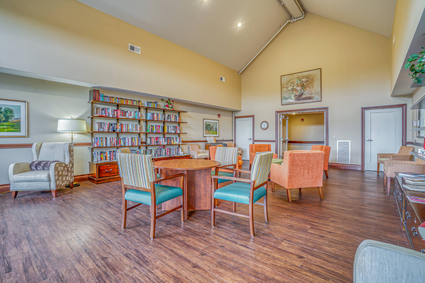 Spacious and comfortable lounge area with bookshelves, seating, tables, and decor.