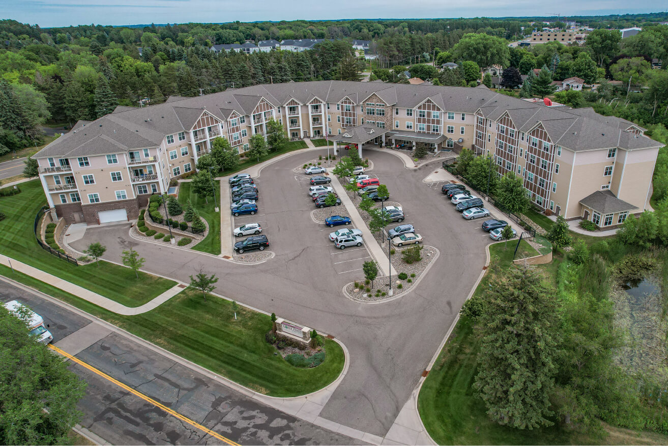 Aerial view of a senior living community with multiple units and a large parking area.
