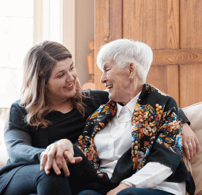 staff member sitting down with senior woman