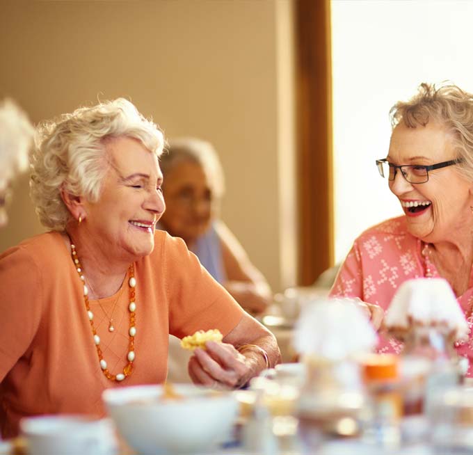 senior women dining and laughing