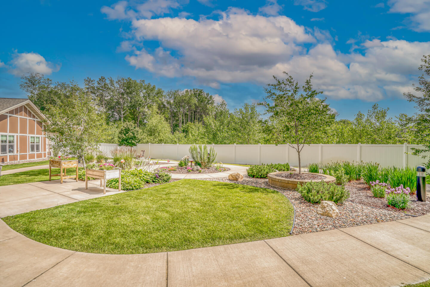 Beautiful landscaped garden with walking paths and benches at a senior living community.