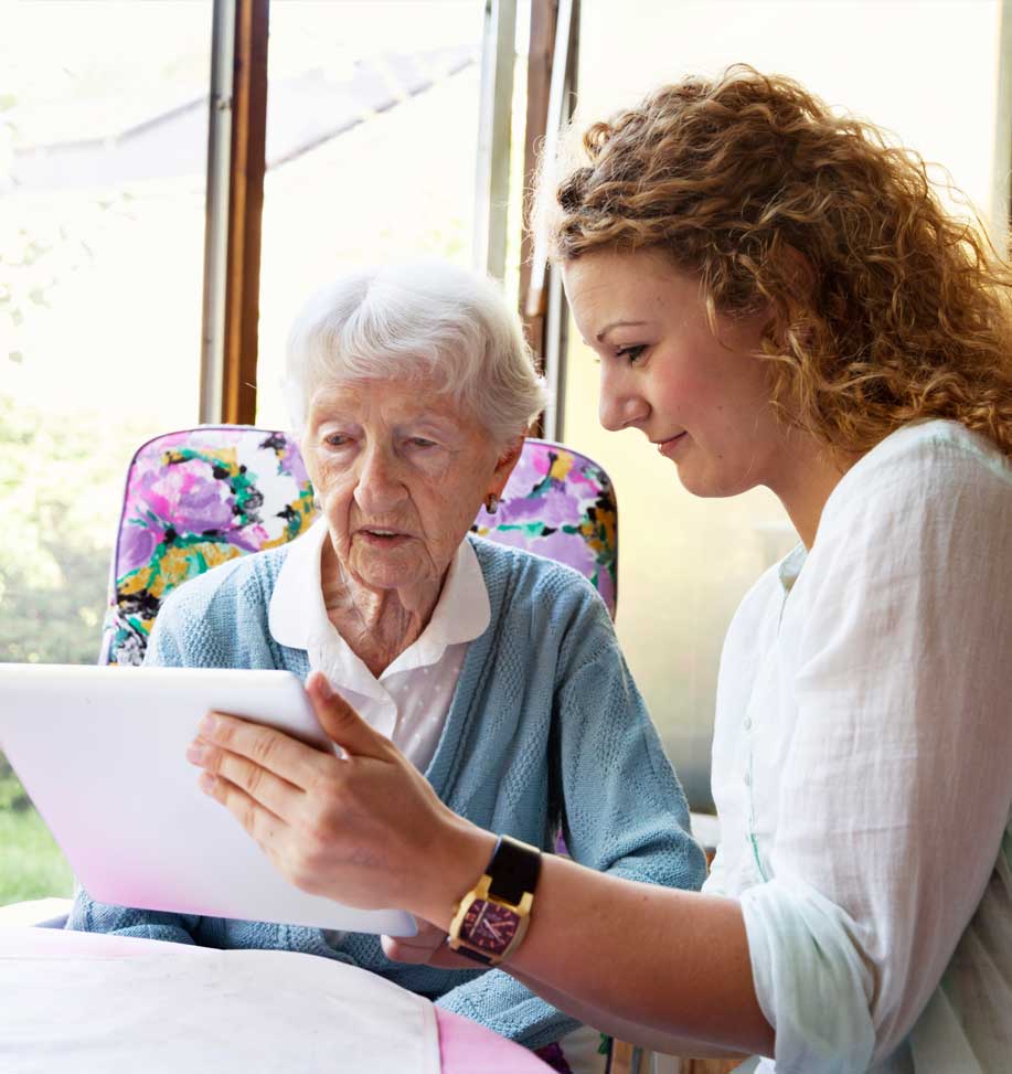 staff helping senior with tablet