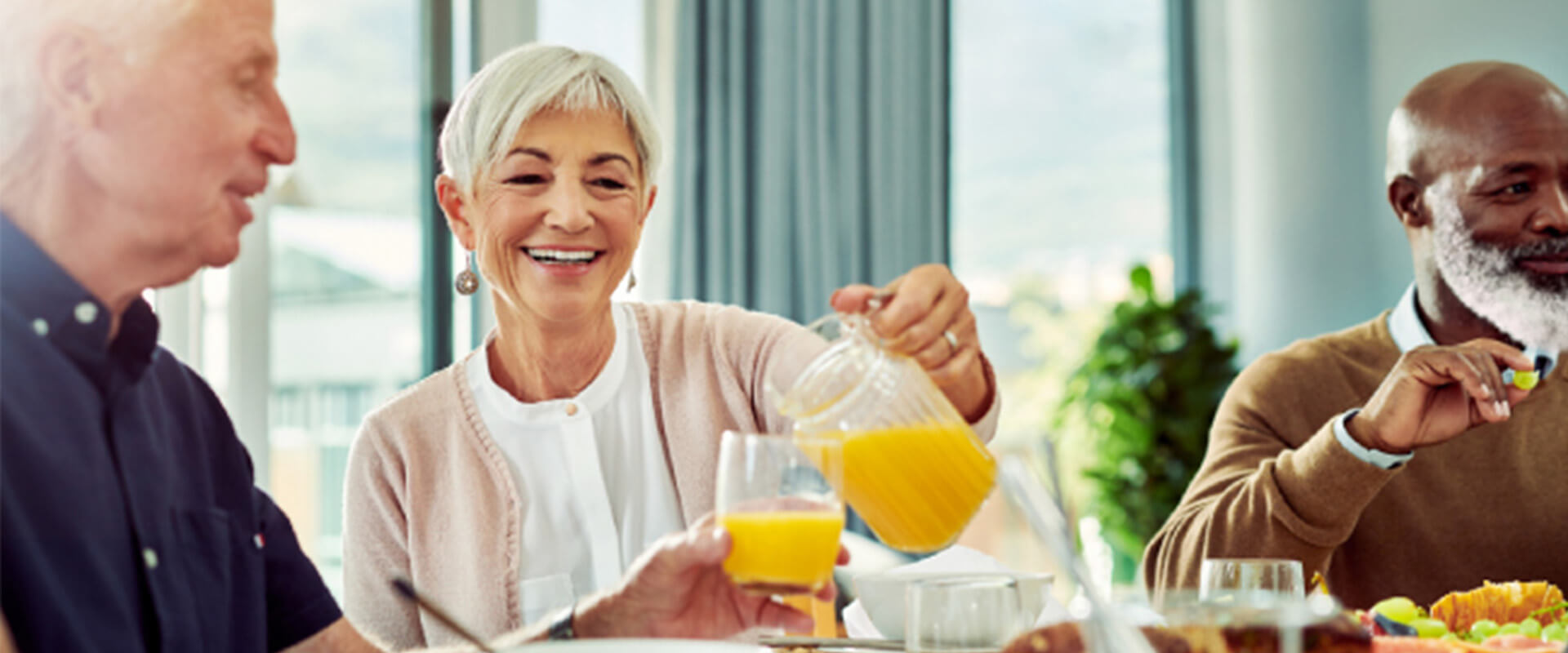 Seniors sit around table and have breakfast